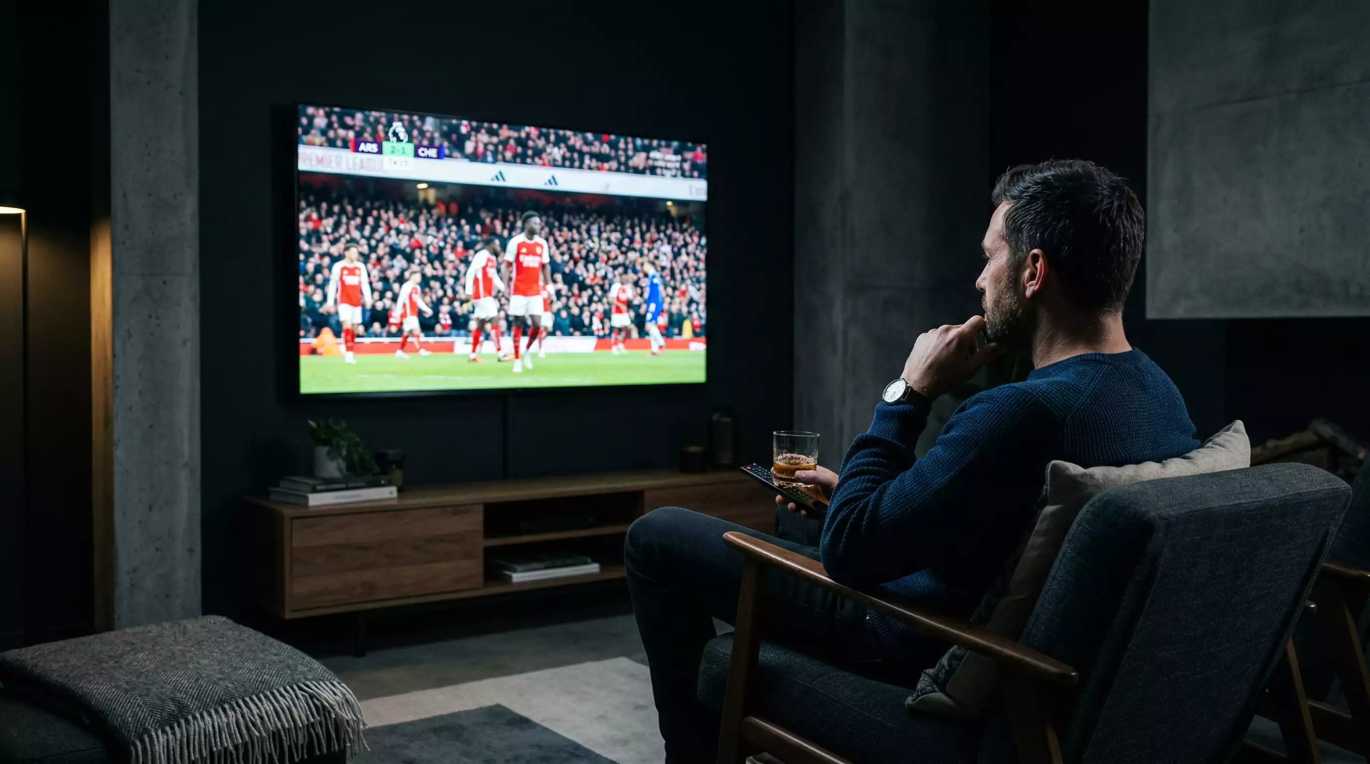 Persoon die geconcentreerd een voetbalwedstrijd volgt met intense blik